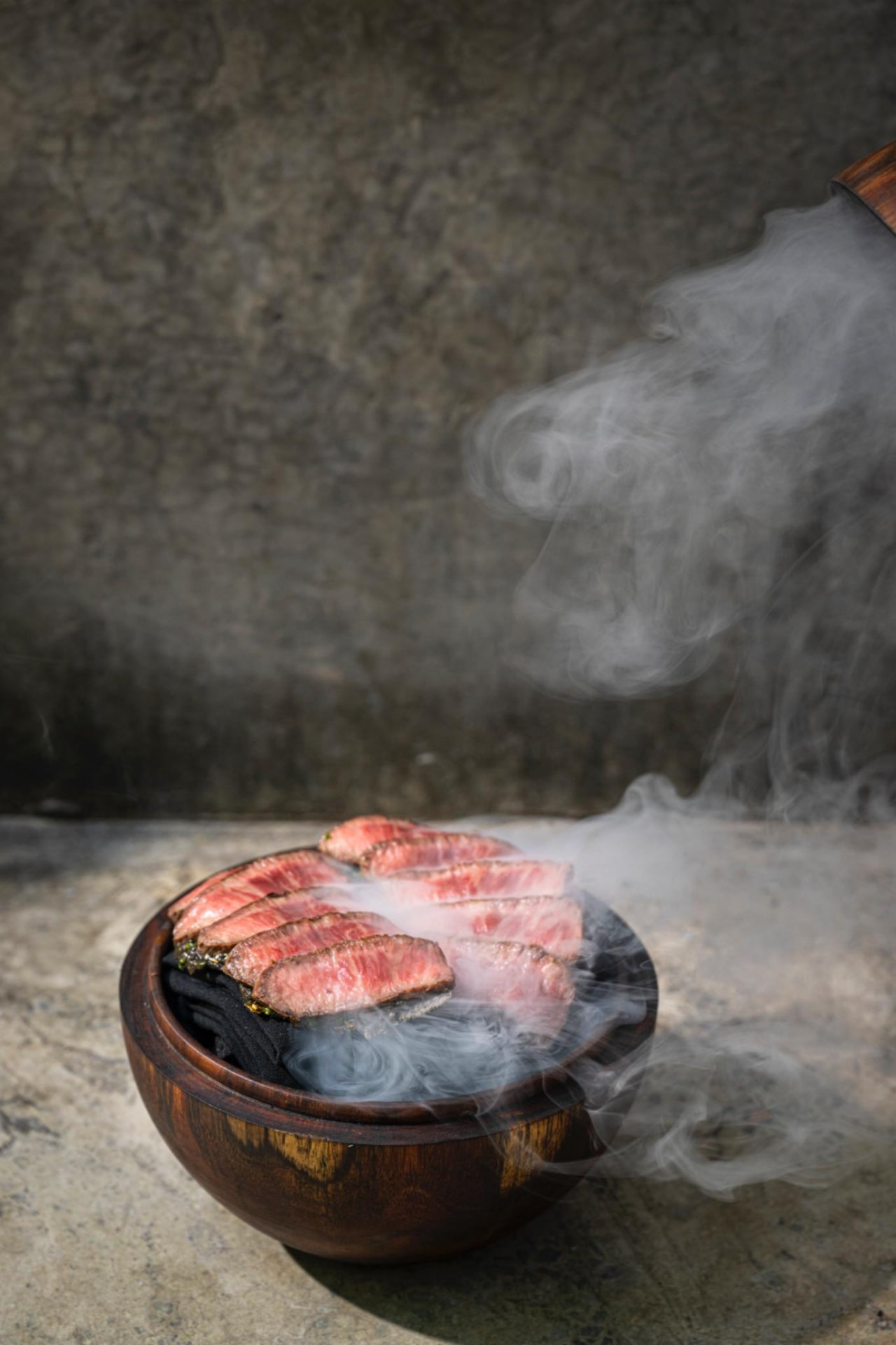 Tlayuda de wagyu mexicano con cortes de carne sobre cuenco de barro humeante, ARCA Tulum